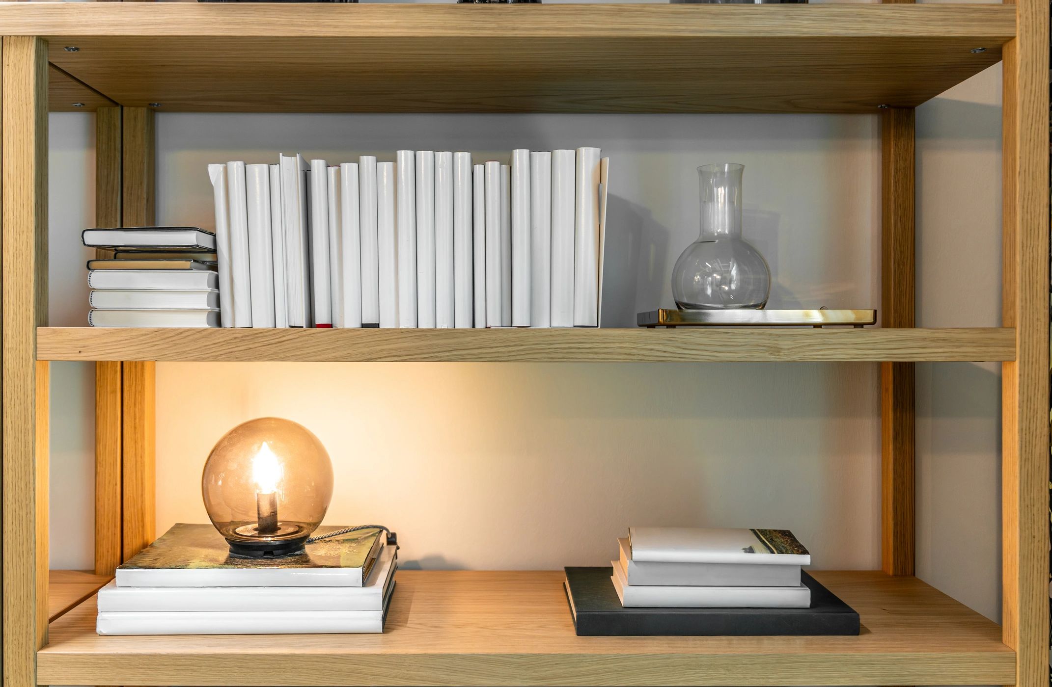 Books displayed on a light wood shelf
